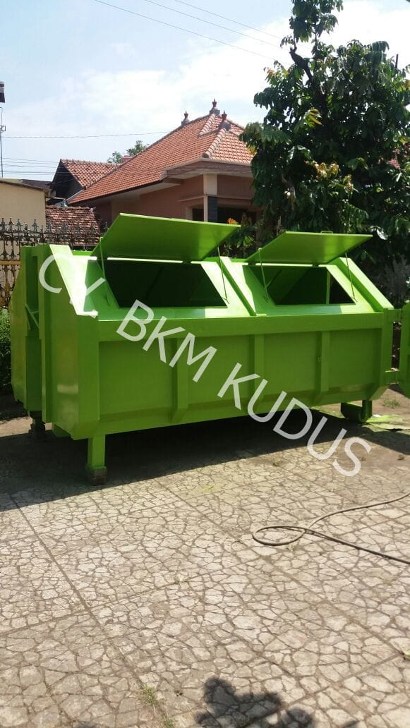 Tempat sampah hijau beroda di halaman kantor